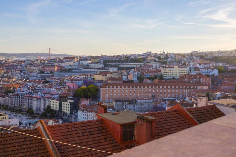 Lisbon rooftops and the Tagus river in warm late afternoon light