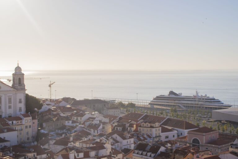 Alfama rooftops and the Tagus at dawn