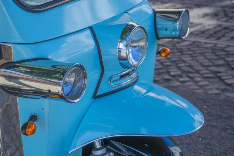 Close-up of the chrome headlight and light blue bodywork of a Chico Chico Tours tuk-tuk