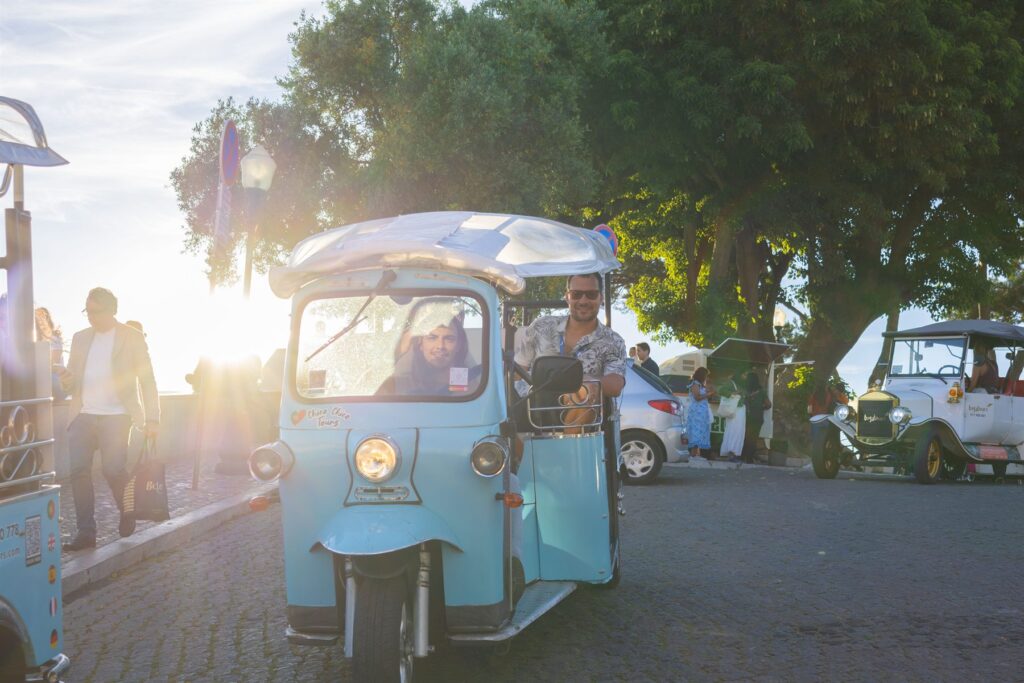 A Chico Chico Tours tuk-tuk on an empty Lisbon street in golden early morning light
