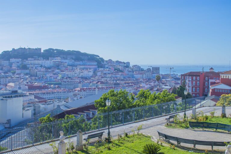 View across Lisbon rooftops towards Sao Jorge Castle from a miradouro